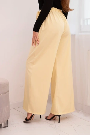 Spodnie damskie eleganckie z szeroką nogawką i ozdobnym kwiatem żółte